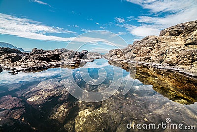 Queen`s Bath on Kauai, Hawaii island. Ocean pond in rocks with sky reflection Stock Photo