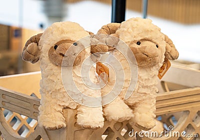 Soft, fluffy sheep plush toys with tags on a wooden shelf in a store. Editorial Stock Photo