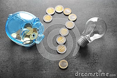 Question mark made of coins, piggy bank and light bulb on grey background. Electricity saving concept Stock Photo