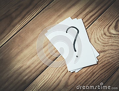 Question mark in paper on a wood background. Stock Photo