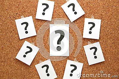 Question mark on a piece of paper and many question marks on cork board. Stock Photo