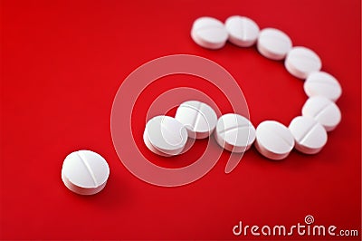 Question mark of white tablets on red Stock Photo