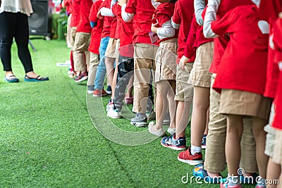 Queue of Asian kids in school uniform standing in line Stock Photo