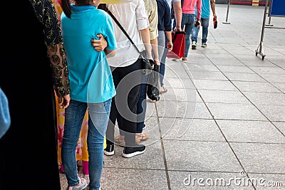 Queue of Asian people wait in line in urban street Editorial Stock Photo