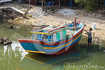 Qui Nhon, Vietnam - Apr 1, 2016: Fishing boat is painting by fisherman by river in Qui Nhon city, Tay Nguyen, central highlands of Editorial Stock Photo