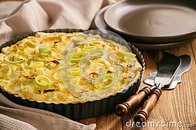 Quiche with leek and cheese on brown background. Stock Photo