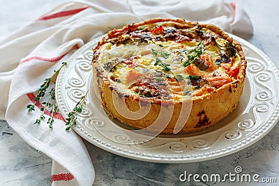 Quiche with salmon, broccoli,red pepper and thyme. Stock Photo
