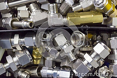 Quick connect fitting coupling for compressed air, hydraulics, pneumatics, gases, fuels lie in a chaotic manner in the box Stock Photo