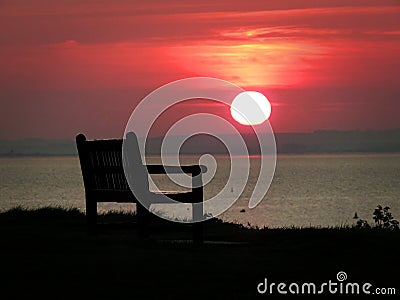 Quiet contemplation sunset beach bench Stock Photo