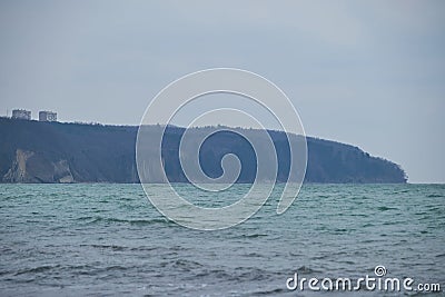 The ocean is blue and turquoise and waves with sea foam. Quiet and exciting black Sea and rock and forest in background. Nature of Stock Photo