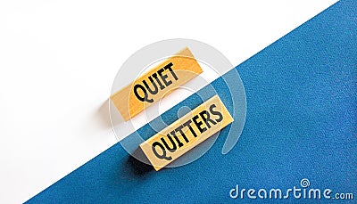 Quiet quitters symbol. Concept words Quiet quitters on wooden blocks. Beautiful white and blue background. White and blue paper. Stock Photo