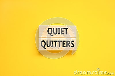 Quiet quitters symbol. Concept words Quiet quitters on wooden blocks. Beautiful yellow table yellow background. Business and quiet Stock Photo