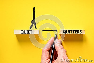 Quiet quitters symbol. Concept words Quiet quitters on wooden blocks. Beautiful yellow table yellow background. Businessman hand. Stock Photo