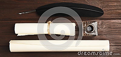 Quill, inkwell and paper rolls on wooden table, flat lay. Banner design Stock Photo