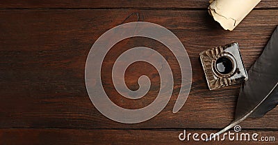 Quill, inkwell and parchment scroll on wooden table, flat lay with space for text. Banner design Stock Photo
