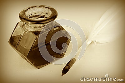 Quill pen and glass ink bottle, sepia style Stock Photo