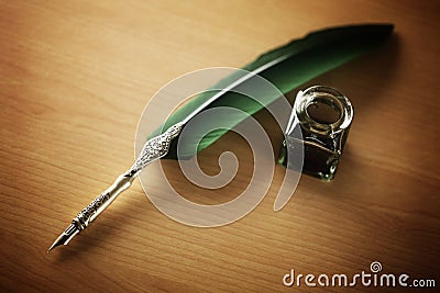 Quill pen and ink well on desk Stock Photo