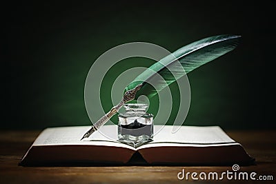 Quill pen and inkwell on old book Stock Photo