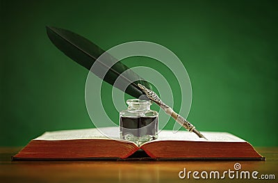 Quill pen and inkwell on old book Stock Photo