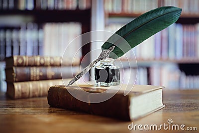 Quill pen on an old book in a library Stock Photo