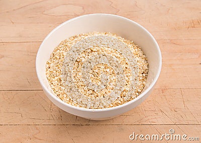 Quinoa flakes in a round glass bowl on wood Stock Photo