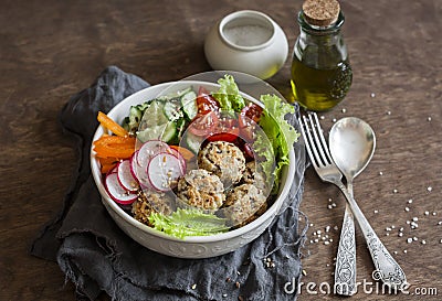 Quinoa meatballs and vegetable salad. Buddha bowl on a wooden table, top view. Healthy, diet, vegetarian food concept. Stock Photo