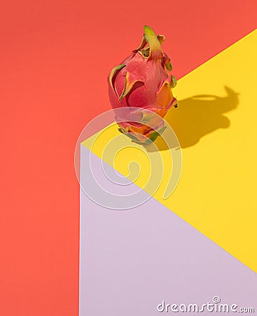 Quirky and amazing concept of exotic fresh dragon fruit. Bright yellow, purple and red background Stock Photo