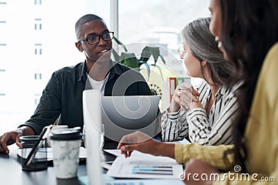Quit asking whats wrong, tell me whats right. a group of businesspeople brainstorming and using a laptop in a modern Stock Photo