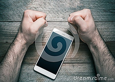 Quit Using Smartphone Or Social Media Concept With A White Mobile Phone Surrounded By 2 Stressed Looking Clenched Fists Stock Photo