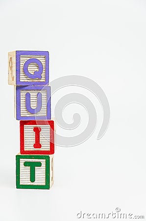 QUIT word wooden block arrange in vertical style on white background and selective focus Stock Photo