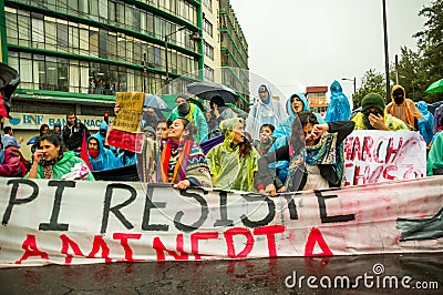 Quito, Ecuador - August 27, 2015: Group of angry mixed young people holding up banner and protesting angrily in city Editorial Stock Photo