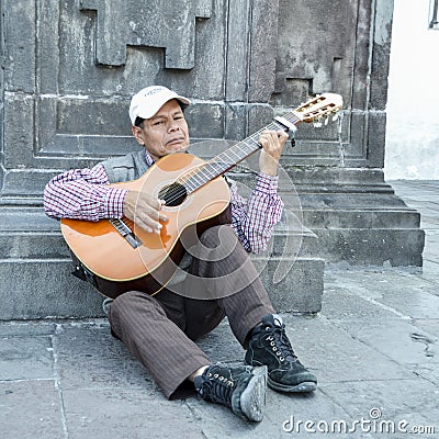 Local Ecuadorian older man plays guitar on the street Editorial Stock Photo
