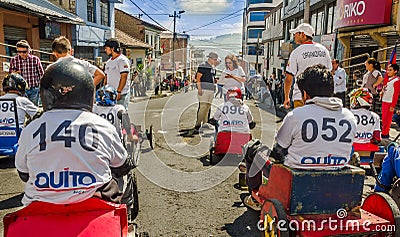 QUITO, ECUADOR - JANUARY 31, 2018: Unidentified boys racing a wooden car in the streets of city of Quito, back view Editorial Stock Photo