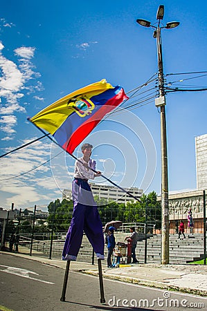 QUITO, ECUADOR - OCTOBER 23, 2017: Close up of young school student holding a ecuadorian flag in his hands and waking Editorial Stock Photo