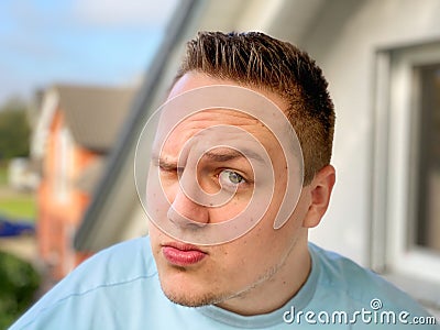 Quizzical young man raising an eyebrow Stock Photo