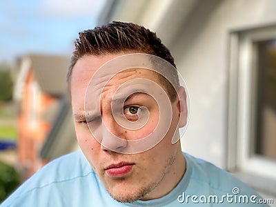 Quizzical young man raising an eyebrow Stock Photo