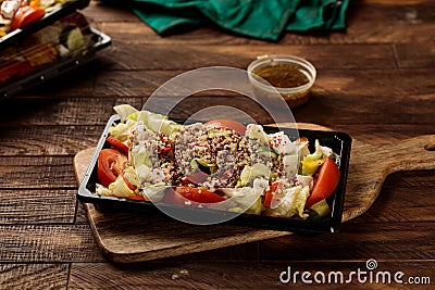 Qunioa salad with beans, tomato, cucumber and sauce served in a dish isolated on wooden table background side view of salad Stock Photo