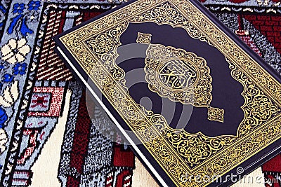 Qur'an over Muslim prayer carpet Stock Photo