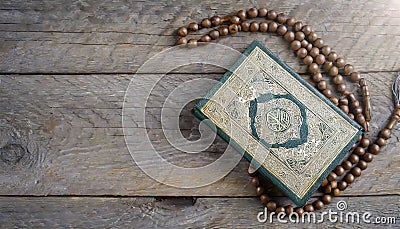 Quran and beads on wooden table Stock Photo