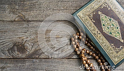 Quran and beads on wooden table Stock Photo