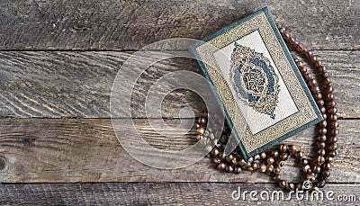 Quran and beads on wooden table Stock Photo