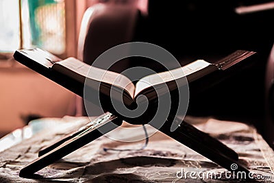 Quran on a rihal or wooden book stand at home Stock Photo