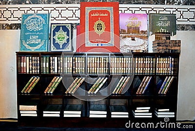 Quran text books inside a wooden bookshelf in different sizes, translation of Arabic text (The noble Quran) Editorial Stock Photo