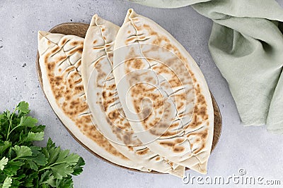 Qutab with green and sour cream or yogurt on gray background. Azerbaijani flat bread with greens. Top view. Stock Photo