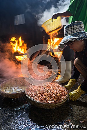 Quy Nhon, Vietnam - Oct 22, 2016: Seafood processing at fish market in Quy Nhon, south Vietnam. Fresh fish or shrimp boiling on bi Editorial Stock Photo