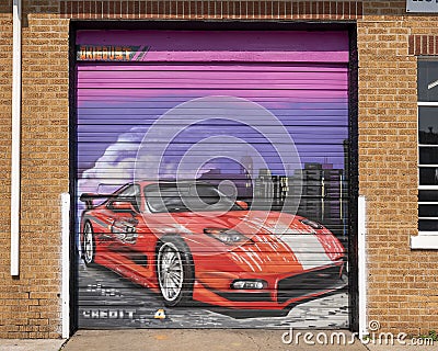 Race car painted on rolling garage door at Pro-Am Garage in the Plaza District of Oklahoma City, by artist Dusty Gilpin. Editorial Stock Photo