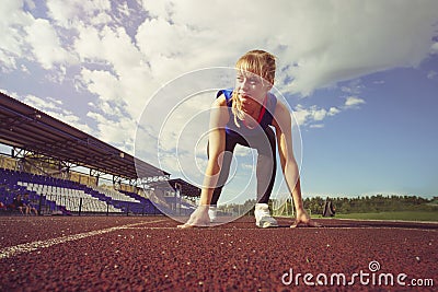 Race Fit confident woman in starting position ready for running. Female athlete about to start a sprint looking away. young runner Stock Photo