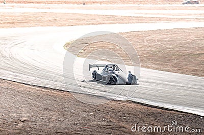 Racecar negotiating sharp desert track curve, demonstrating racing dynamics with high-velocity precision Stock Photo