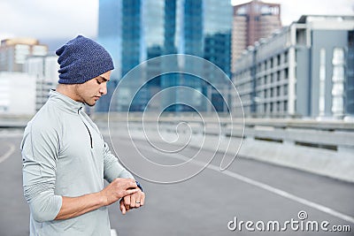 Racing against time. a young jogger checking the time while out for a run in the city. Stock Photo