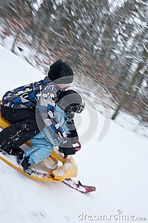 Racing downhills on a snow sledge Stock Photo